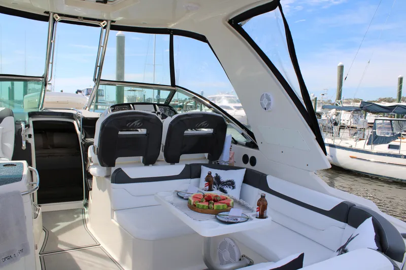 Slide: The Image of 2013 Monterey 340 Sport Yacht interior with seating and table, docked at marina. - 48