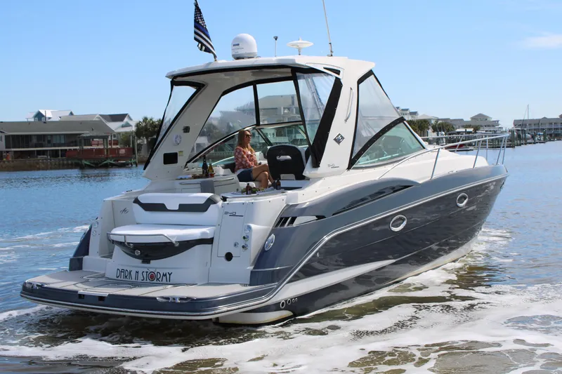 Slide: The Image of 2013 Monterey 340 Sport Yacht cruising on a sunny day, with waterfront homes in the background. - 6