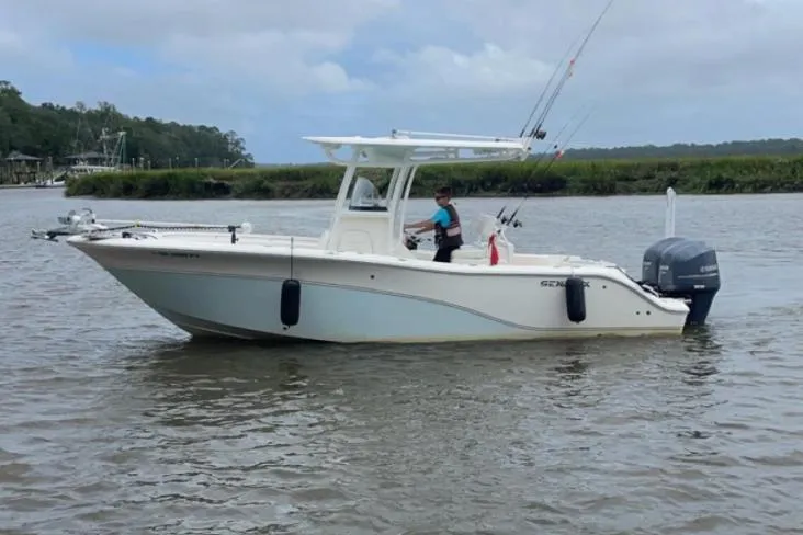 Slide: The Image of 2014 Sea Fox 256 Commander boat on calm water, featuring fishing rods and outboard motor. - 16