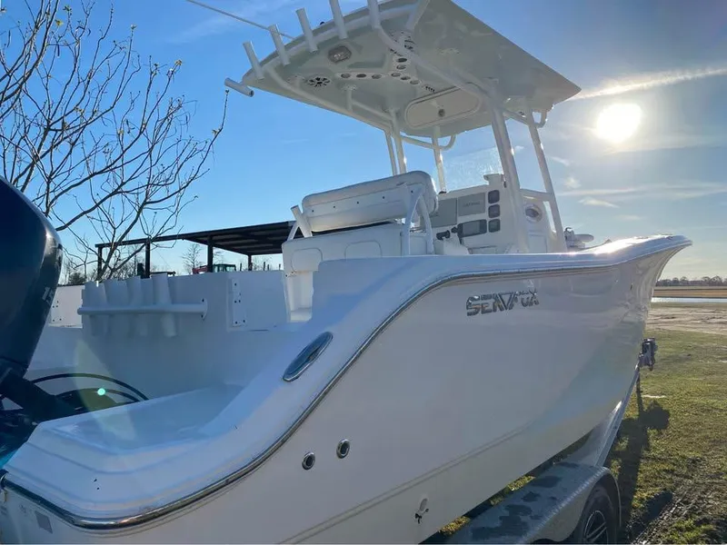 Slide: The Image of 2014 Sea Fox 256 Commander boat, white exterior, parked on trailer, sunny day. - 4