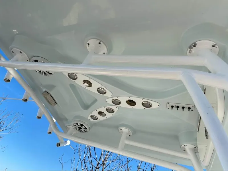 Slide: The Image of 2014 Sea Fox 256 Commander boat canopy with speakers and rod holders against blue sky. - 9