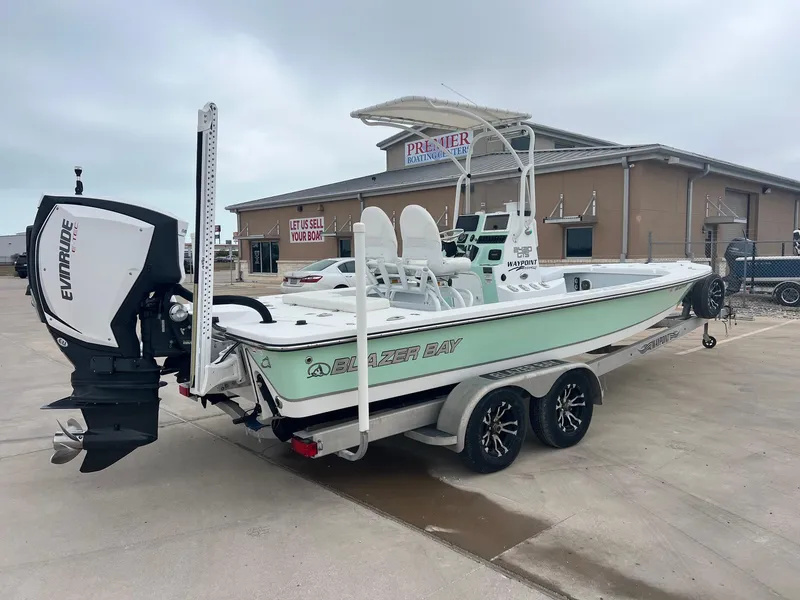 Slide: The Image of 2018 Blazer 2420 GTS boat with Evinrude engine on trailer at dealership. - 11