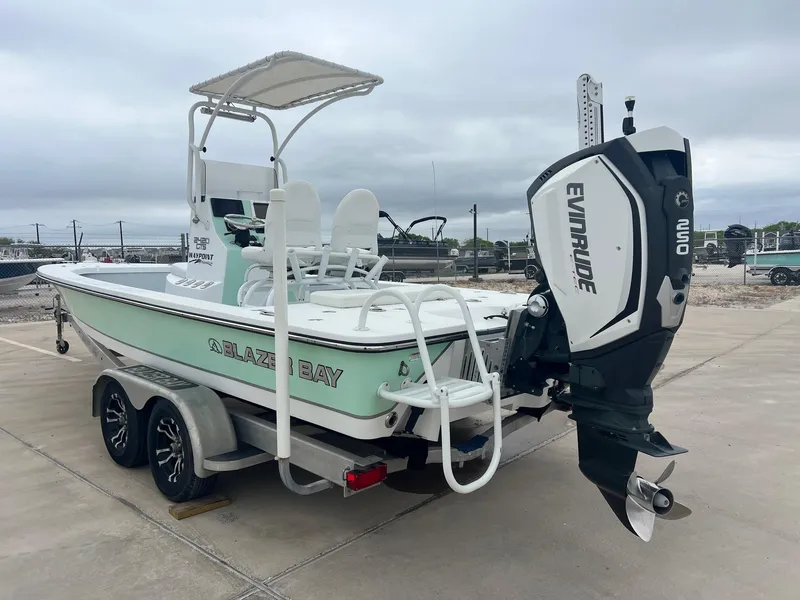 Slide: The Image of 2018 Blazer 2420 GTS boat with Evinrude engine on trailer, parked outdoors. - 13