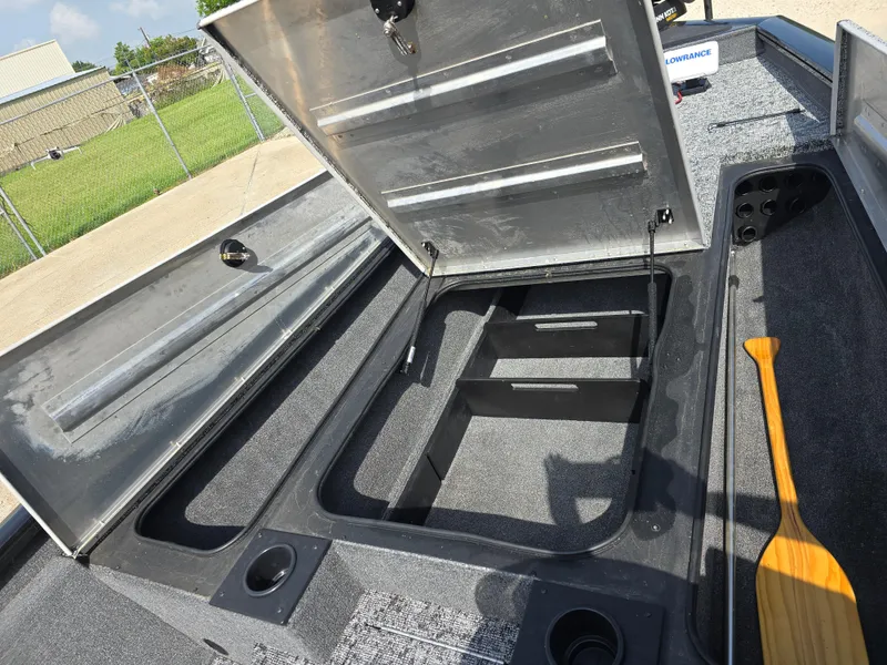 Slide: The Image of 2024 Bass Tracker PRO TEAM 190 boat storage compartments with open lids and paddle. - 10