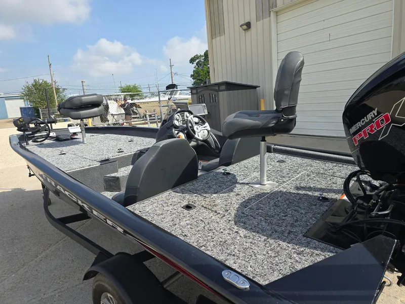 Slide: The Image of 2024 Bass Tracker PRO TEAM 190 boat with Mercury engine, parked outdoors. - 8