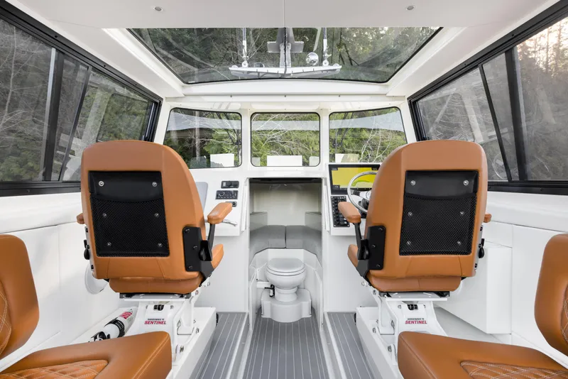 Slide: The Image of Interior of 2025 Jasper Marine Defender 22 boat with brown seats and modern controls. - 3