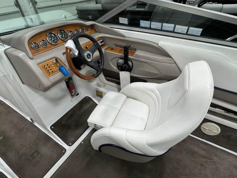 Slide: The Image of Interior of a 2001 Cobalt 246 boat with white leather seating and wooden dashboard. - 11