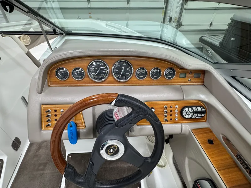 Slide: The Image of 2001 Cobalt 246 boat dashboard with wood accents and steering wheel. - 12