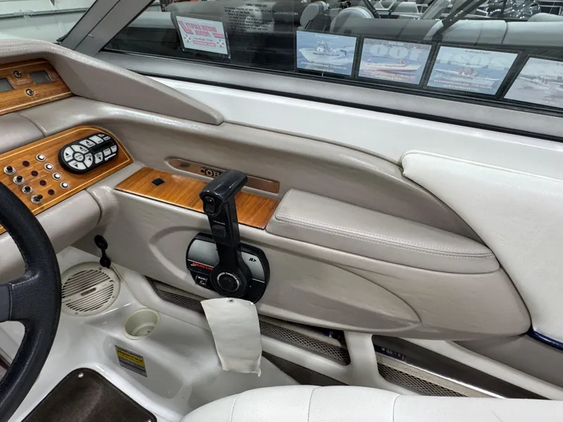 Slide: The Image of Interior of a 2001 Cobalt 246 boat with wood accents and control panel. - 13