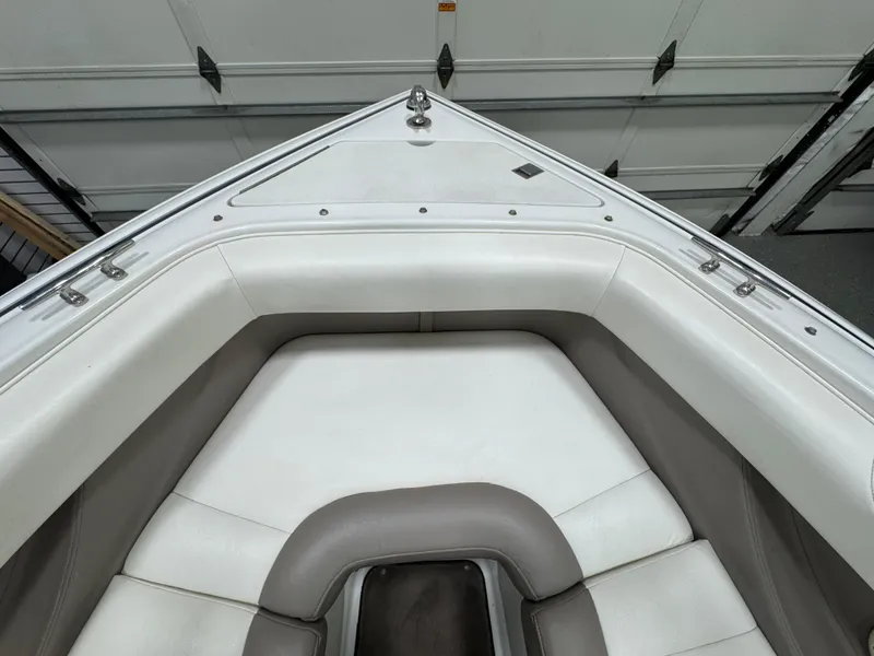 Slide: The Image of 2001 Cobalt 246 boat interior with white and gray seating in a garage. - 21