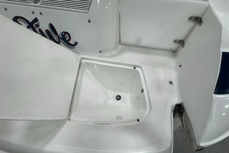 Slide: The Image of 2001 Cobalt 246 boat deck with storage compartment and visible drain. - 23