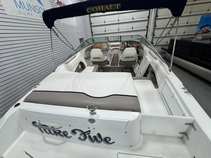 Slide: The Image of 2001 Cobalt 246 boat interior with seating and dashboard, displayed in a showroom. - 4