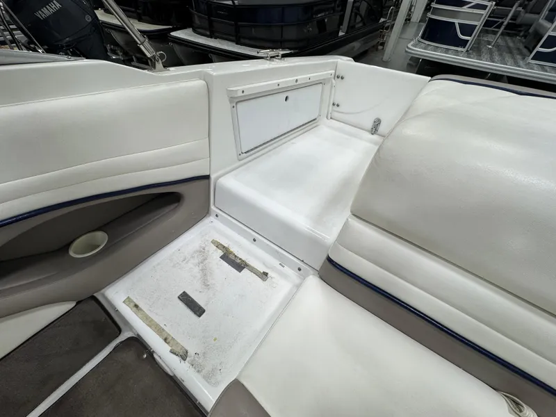 Slide: The Image of 2001 Cobalt 246 boat interior with white seating and storage compartment. - 6