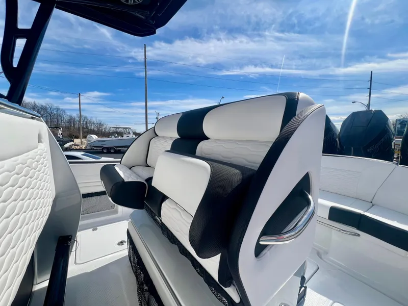 Slide: The Image of 2025 Nor-Tech 390 Sport Center Console boat with sleek seating design under a clear blue sky. - 22