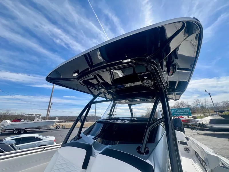 Slide: The Image of 2025 Nor-Tech 390 Sport Center Console boat with sleek black canopy under a blue sky. - 47