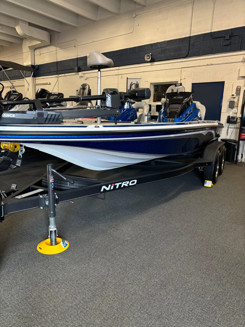 Slide: The Image of 2024 Nitro Z18Pro boat in showroom, featuring sleek design and dual axle trailer. - 4