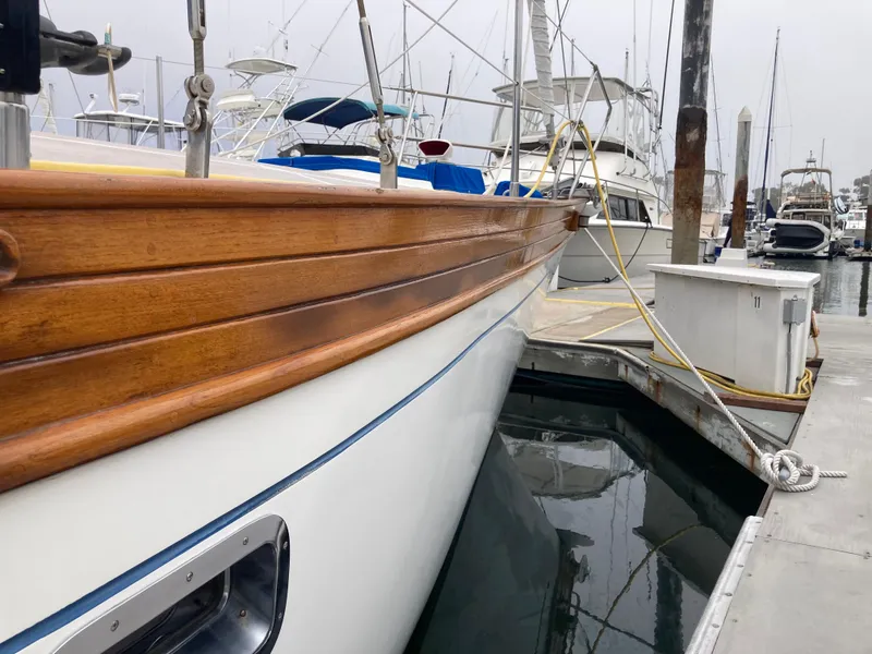 Slide: The Image of 1984 Nantucket Island 33 boat docked at marina with wooden trim and calm water. - 10