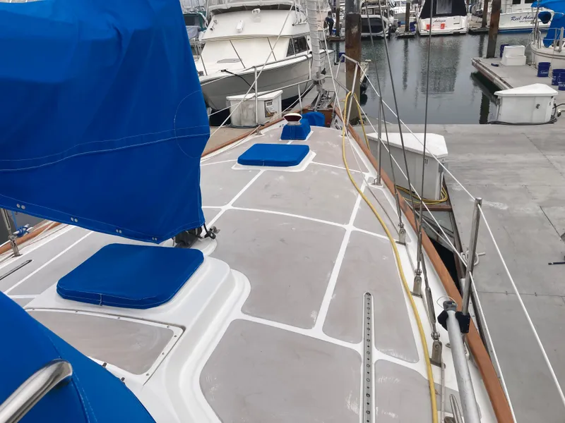 Slide: The Image of 1984 Nantucket Island 33 sailboat docked, featuring blue covers and a clean deck. - 14