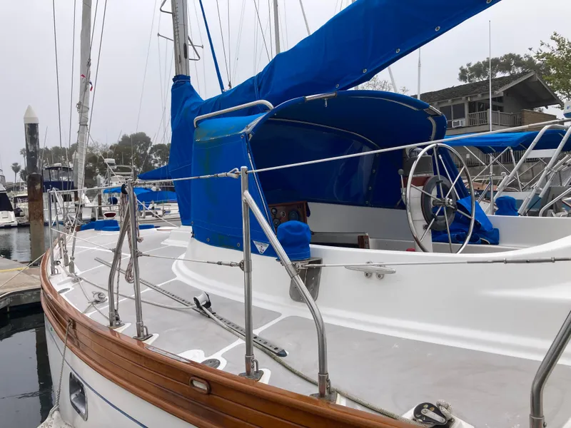 Slide: The Image of 1984 Nantucket Island 33 sailboat with blue covers docked at marina. - 19