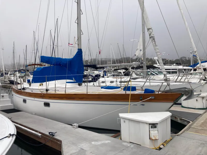 Slide: The Image of 1984 Nantucket Island 33 sailboat docked at marina, featuring blue sail covers. - 2