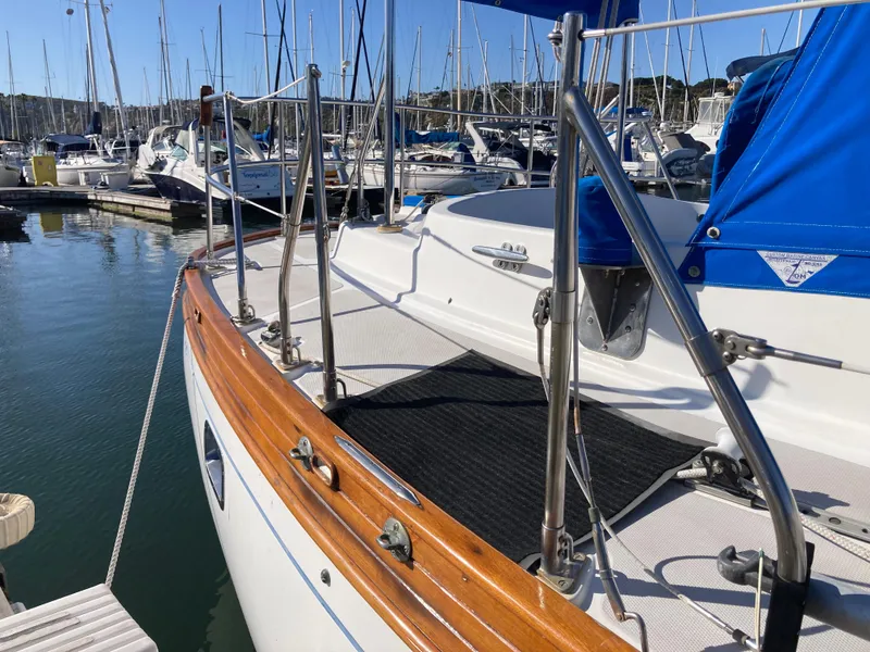 Slide: The Image of 1984 Nantucket Island 33 sailboat docked in marina, featuring wooden trim and stainless steel railings. - 20