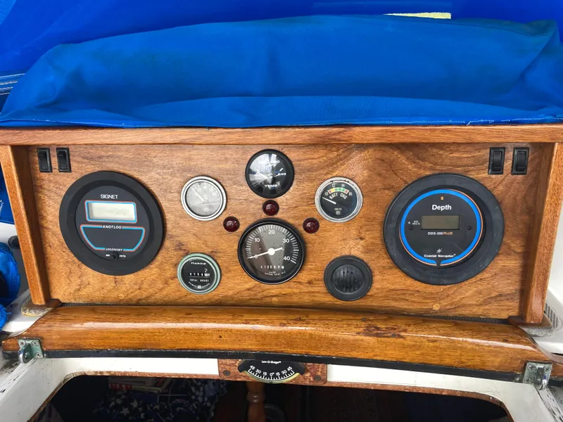 Slide: The Image of Wooden dashboard of a 1984 Nantucket Island 33 sailboat with various gauges and instruments. - 34