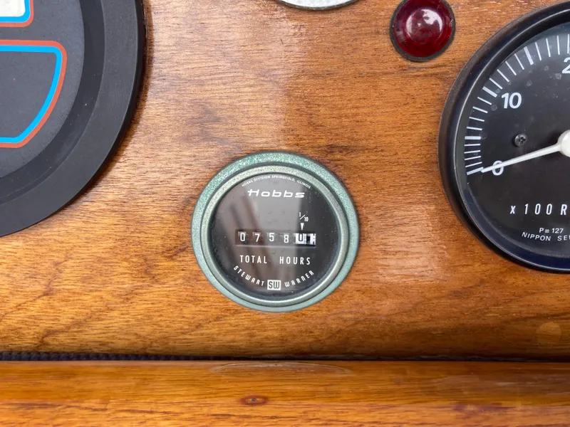 Slide: The Image of Wooden dashboard with Hobbs hour meter showing 758 hours on a Nantucket Island 33, 1984 model. - 35