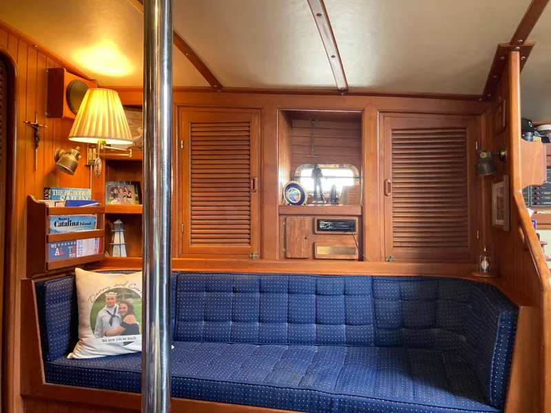 Slide: The Image of Cozy 1984 Nantucket Island 33 yacht interior with blue seating and wooden cabinetry. - 41
