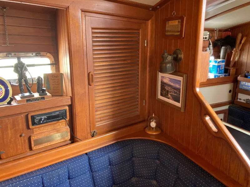 Slide: The Image of Cozy 1984 Nantucket Island 33 yacht interior with wooden cabinetry and blue cushioned seating. - 42