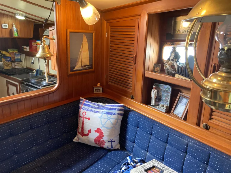 Slide: The Image of Cozy 1984 Nantucket Island 33 yacht interior with nautical decor and blue seating. - 45
