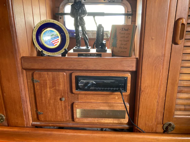 Slide: The Image of Wooden interior of a 1984 Nantucket Island 33 boat with decorative items and a stereo system. - 46