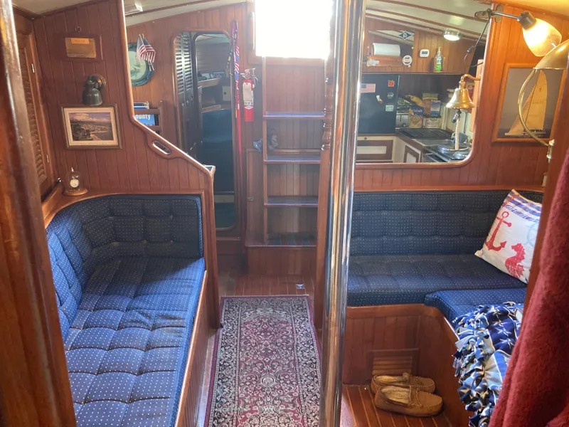 Slide: The Image of Cozy 1984 Nantucket Island 33 yacht interior with blue seating and nautical decor. - 51