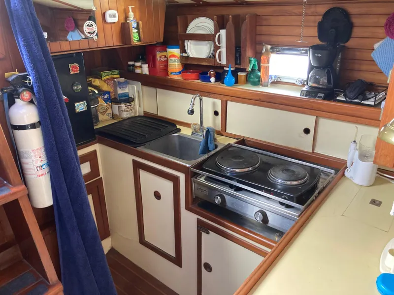 Slide: The Image of Compact 1984 Nantucket Island 33 boat kitchen with stove, sink, and storage. - 52