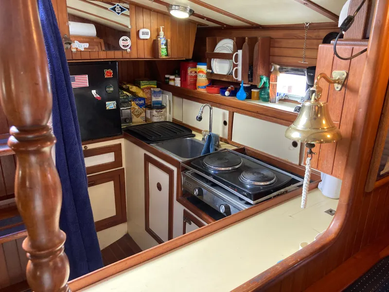 Slide: The Image of 1984 Nantucket Island 33 boat kitchen with stove, sink, and wooden cabinetry. - 53