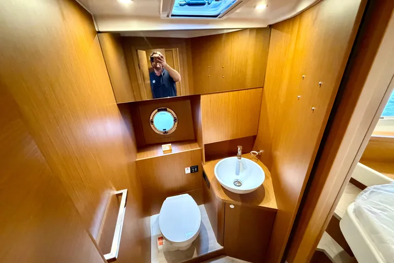 Slide: The Image of 2026 Beneteau Swift Trawler 41 Fly bathroom with wood finish and modern fixtures. - 25