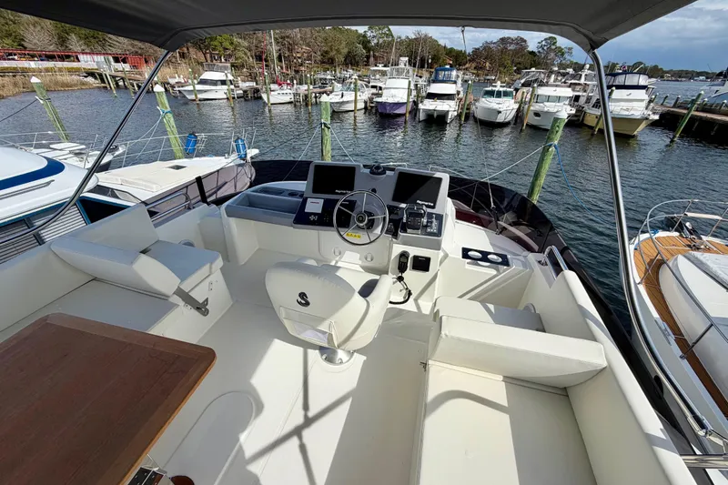 Slide: The Image of 2026 Beneteau Swift Trawler 41 Flybridge, featuring helm station and marina view. - 29