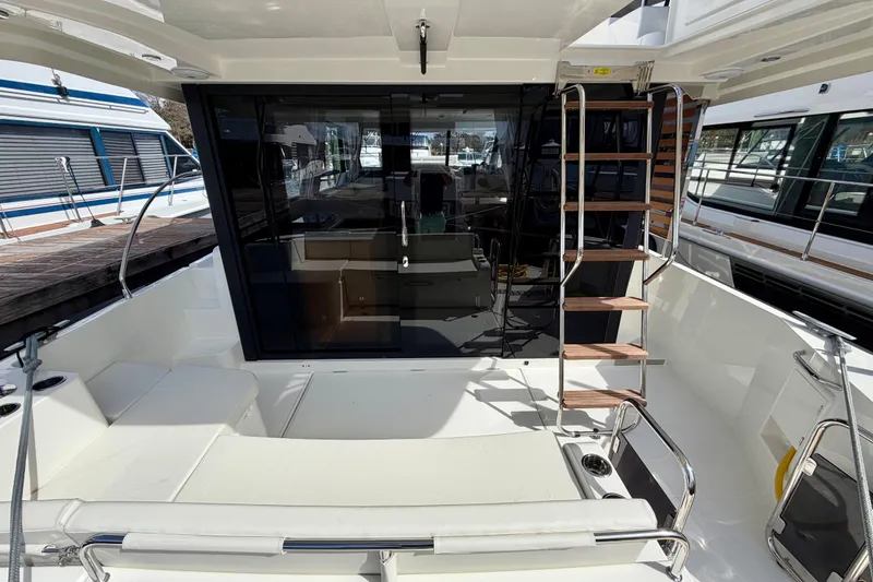 Slide: The Image of 2026 Beneteau Swift Trawler 41 Fly, rear deck view with seating and ladder. - 37