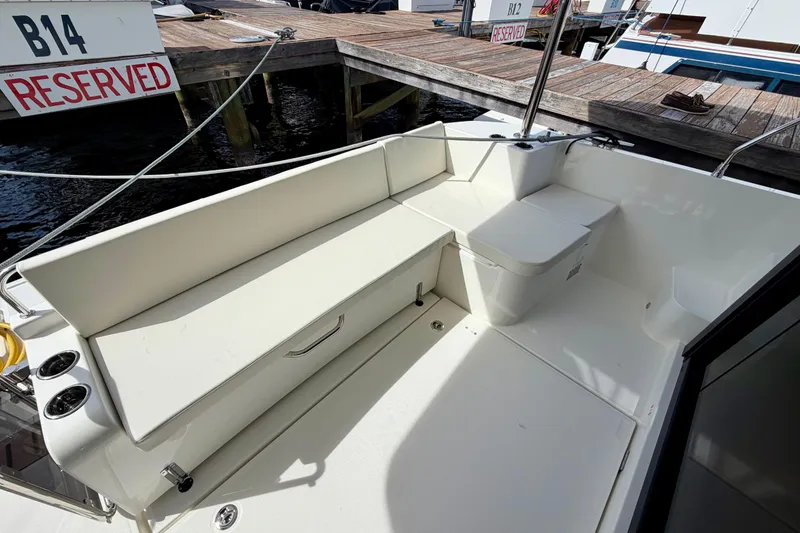 Slide: The Image of 2026 Beneteau Swift Trawler 41 Fly, spacious deck seating area at marina. - 38