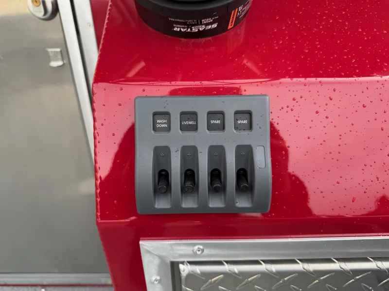 Slide: The Image of Control panel on 2025 Thunder Jet 24 Alexis Pro boat, featuring switches and red surface. - 15