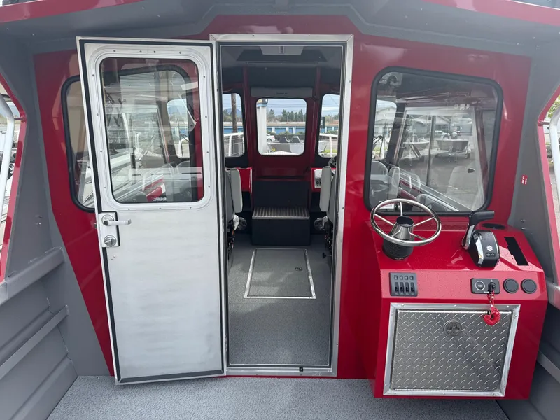 Slide: The Image of 2025 Thunder Jet 24 Alexis Pro boat interior with red and gray design, featuring steering console. - 18