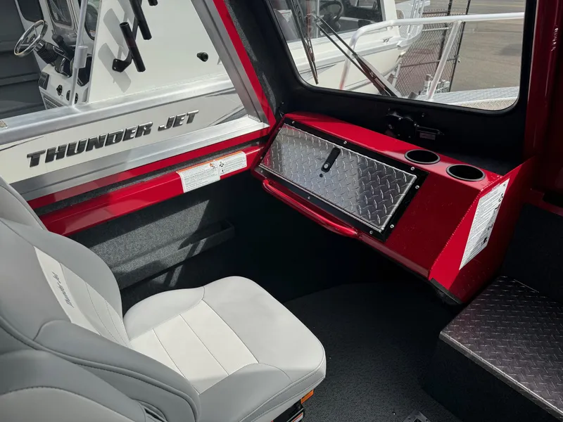 Slide: The Image of Interior of 2025 Thunder Jet 24 Alexis Pro boat with red accents and seating. - 26