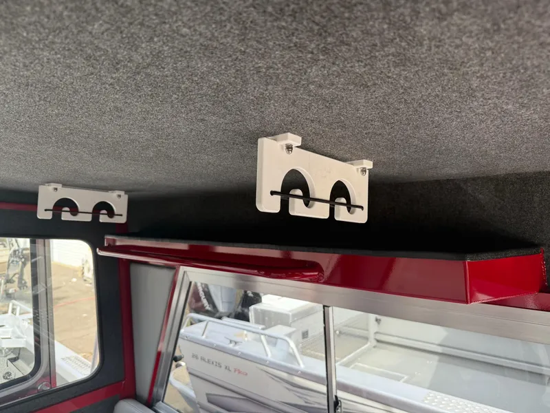 Slide: The Image of Interior of 2025 Thunder Jet 24 Alexis Pro boat with rod holders and storage shelf. - 28