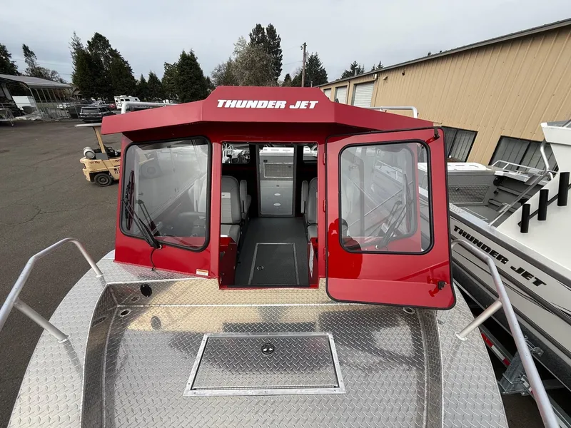 Slide: The Image of 2025 Thunder Jet 24 Alexis Pro boat with red cabin, docked outdoors. - 33
