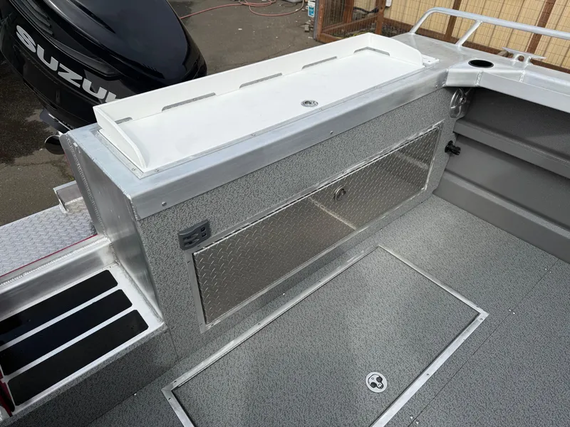 Slide: The Image of 2025 Thunder Jet 24 Alexis Pro boat interior with storage and Suzuki engine. - 8