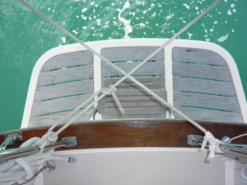 Slide: The Image of Stern view of 2008 Island Packet 465 sailboat with wooden deck and ropes over turquoise water. - 12