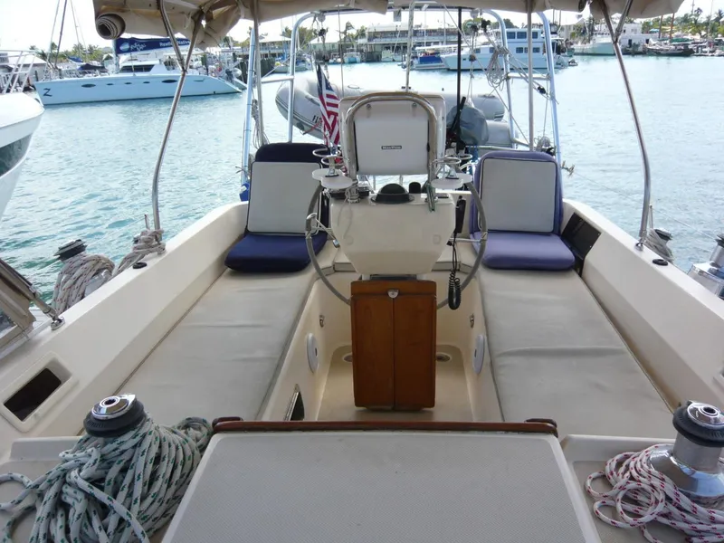 Slide: The Image of 2008 Island Packet 465 sailboat cockpit with helm, seating, and marina view. - 17
