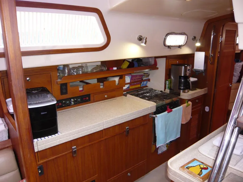 Slide: The Image of Galley of 2008 Island Packet 465 yacht with wooden cabinetry and modern appliances. - 24
