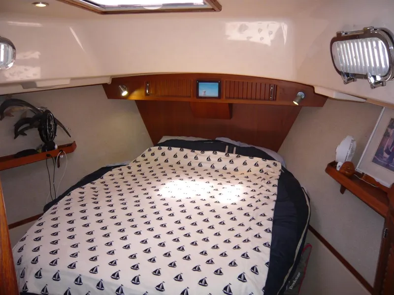 Slide: The Image of Cozy cabin interior of 2008 Island Packet 465 sailboat with nautical-themed bedding. - 28