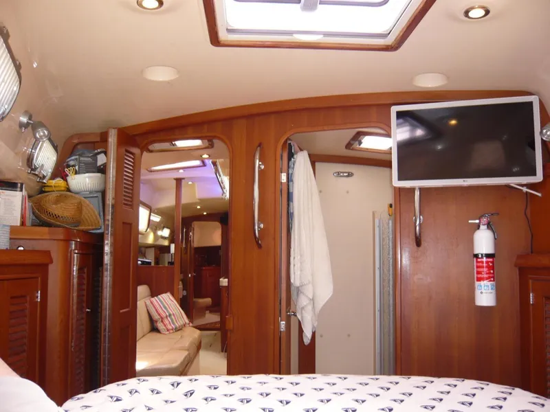 Slide: The Image of 2008 Island Packet 465 yacht interior with wood finish, TV, and cozy seating area. - 29