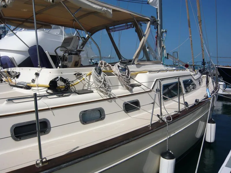 Slide: The Image of 2008 Island Packet 465 sailboat docked, featuring a spacious deck and protective canopy. - 4